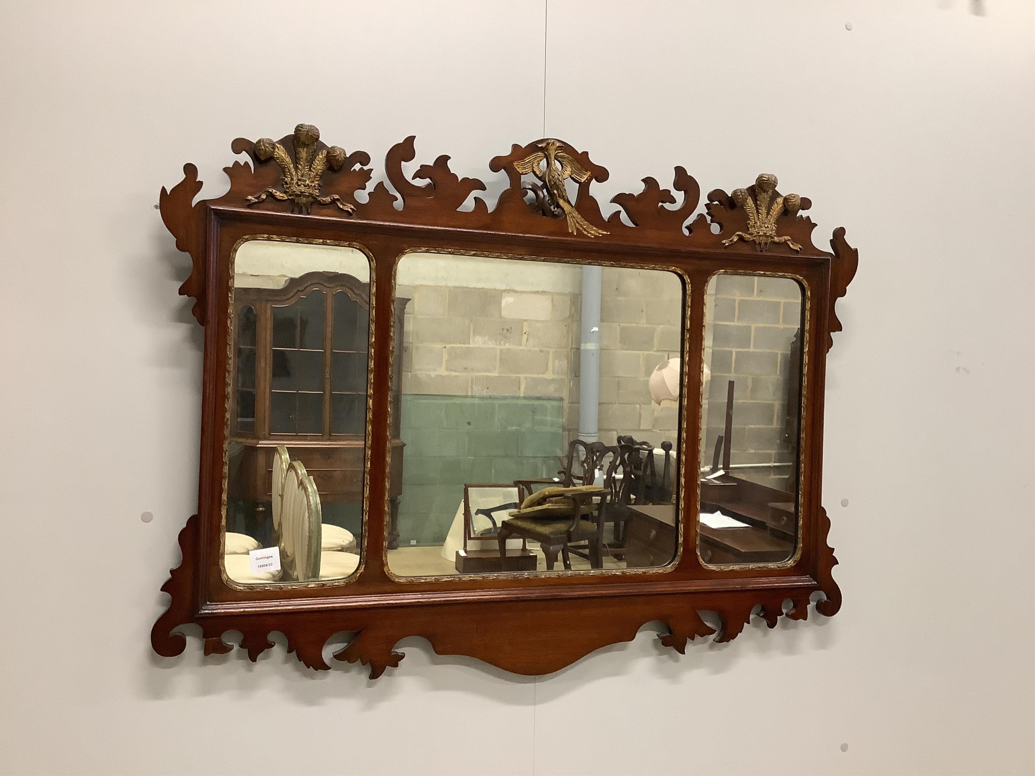 A George III style mahogany, parcel gilt triple plate fret cut wall mirror with Prince of Wales plume and phoenix pediment, width 114cm, height 84cm. Condition - fair to good